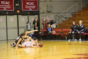 Senior Helen Scheblo dives to wrestle a loose ball away from two Wooster guards.  The Bishops defeated the Scots 76-62 in the final minutes of the game.