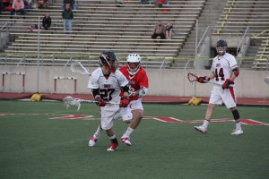 Freshman Tate Rolland looks to pass the ball while being pursued by a Big Red defender. 