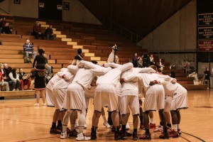 Men's basketball team in a huddle. Photo courtesy of Alex Gross.