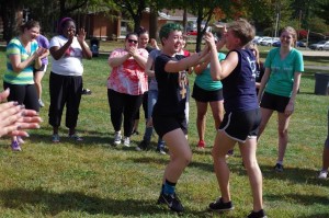 Rowan Hannan (left) and Meredith Harrison celebrate after winning a tug of war match at Delta Zeta's fall philanthropy event, while fellow Women's House residents clap in the background. Photo courtesy of Spenser Hickey.