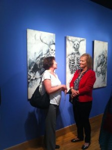 Attendees talk in front of Caroline Bodee's "Egotism" series. Photo courtesy of Adelle Brodbeck.