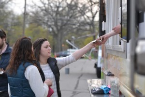 Freshman Laura Benson hands cash to Andrew Tuchow '13 for her food purchase at the Kinetic food truck. Photo courtesy of Spenser Hickey.