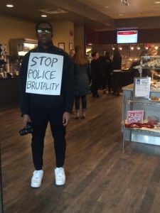 Trent Williams holding his sign in the Hamilton-Williams dining hall. Photo by Courtney Dunne.